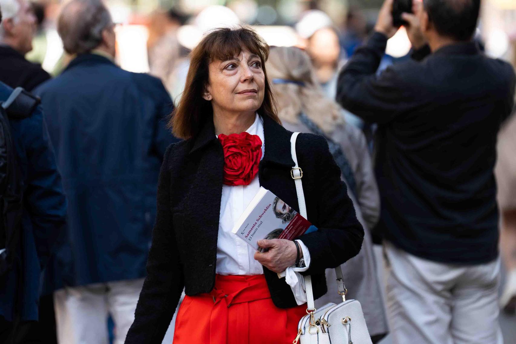 Una dona passejant amb un llibre a la mà pel dia de Sant Jordi