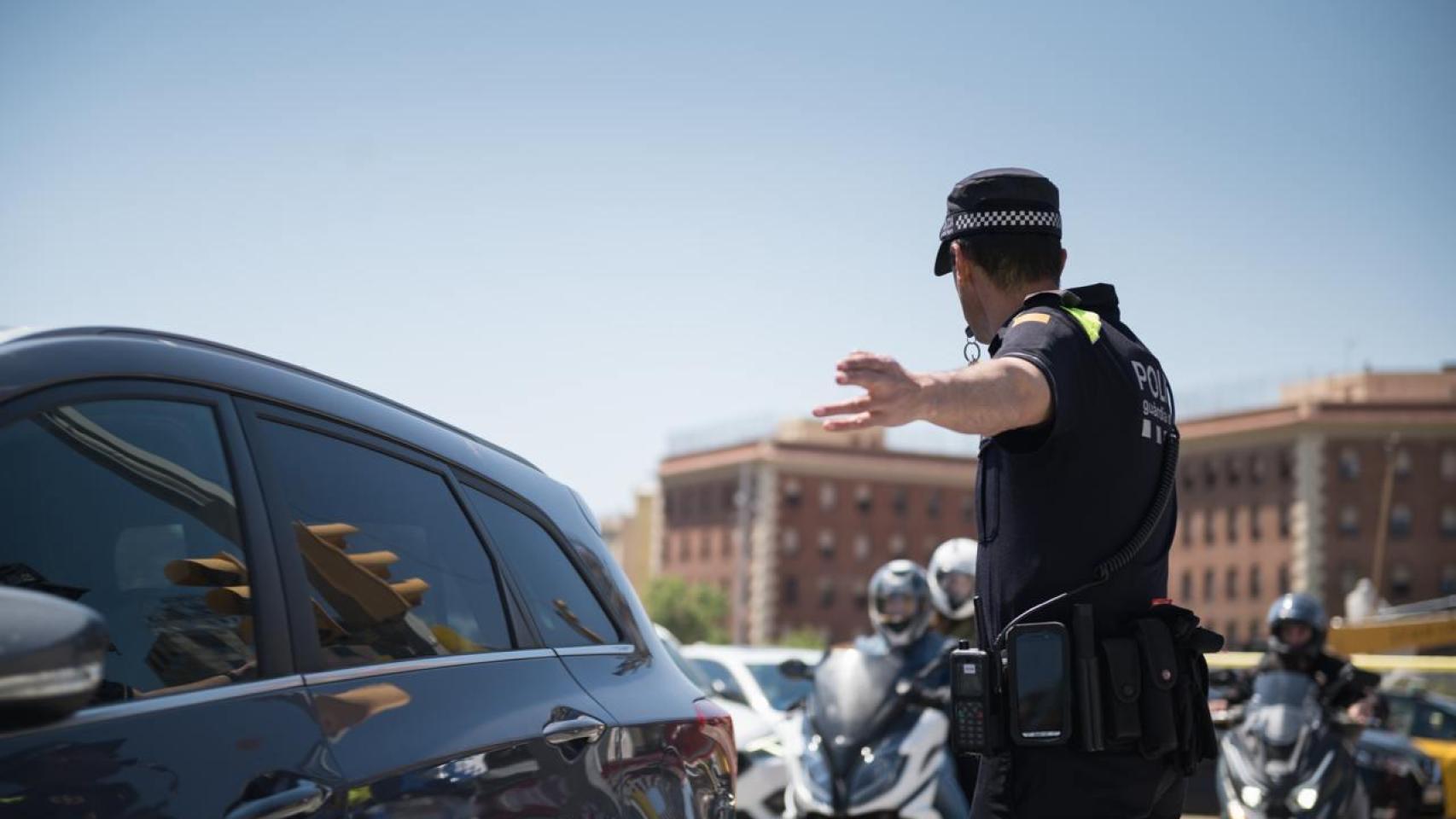 Un agente de la Guardia Urbana controla el tráfico en Barcelona