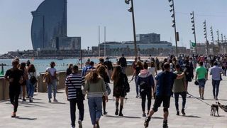Gente paseando por la Barceloneta en un día soleado