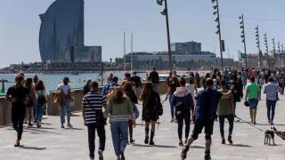 Gente paseando por la Barceloneta en un día soleado