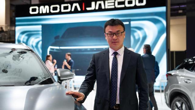 El vicepresidente de Chery, Charlie Zhang, posa junto a un coche Omoda en el Automobile 2025 de Barcelona