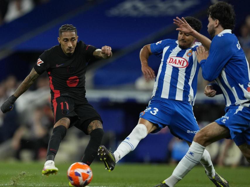 Raphinha remata a portería ante dos futbolistas del Espanyol