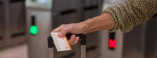 Una viajera sostiene un billete tras cruzar los tornos