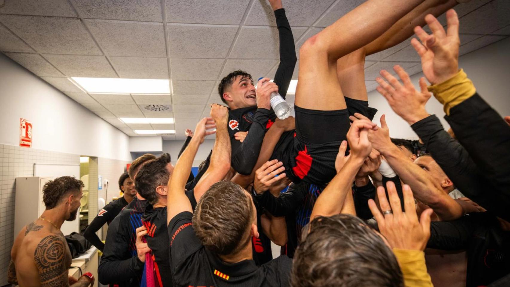 Los jugadores del Barça mantean a Pedri, tras conquistar la Liga en el derbi contra el Espanyol