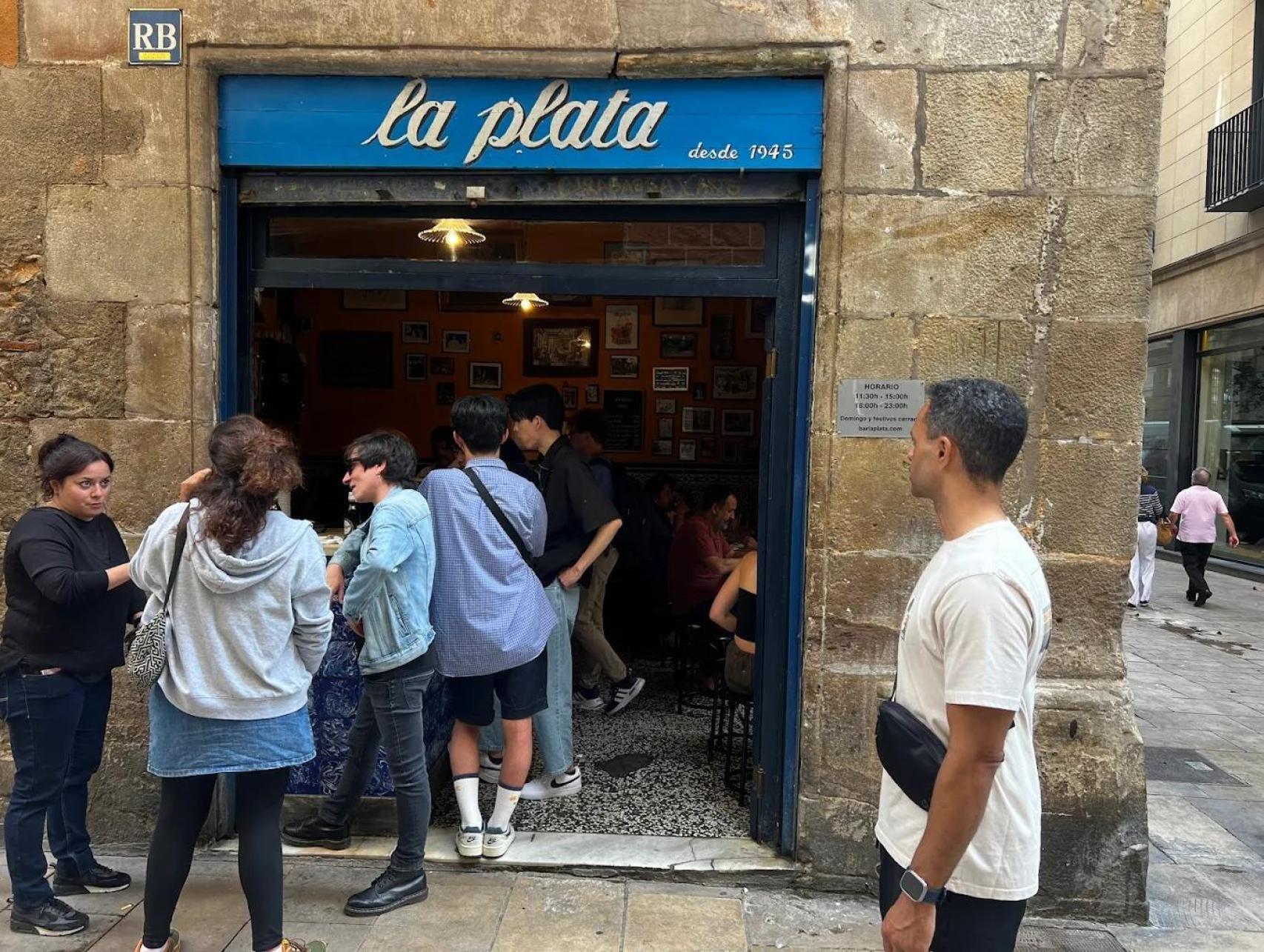 Gent fent cua per menjar al Bar La Plata del Gòtic