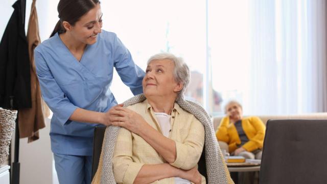 Una persona mayor con ayuda de una profesional sanitaria