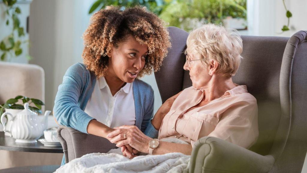 Imatge d'arxiu d'una dona gran amb l'ajuda d'una sanitària