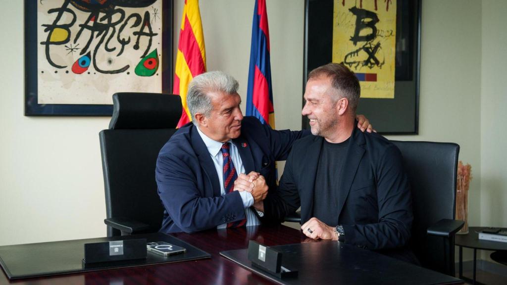 Joan Laporta y Hansi Flick estrechan la mano en el acto de renovación del técnico alemán con el Barça