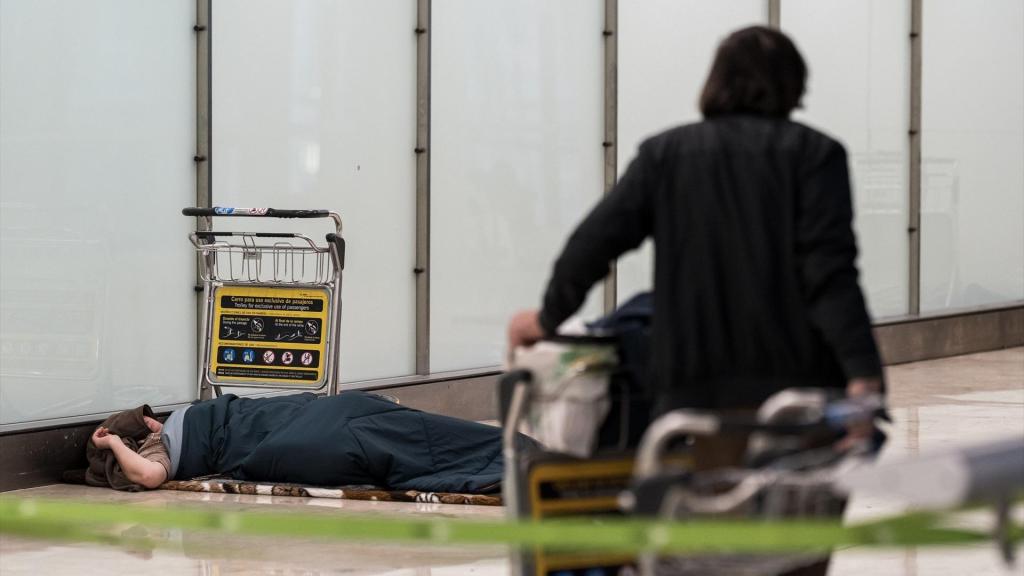 Una persona sense llar dormint a l'Aeroport de Barajas