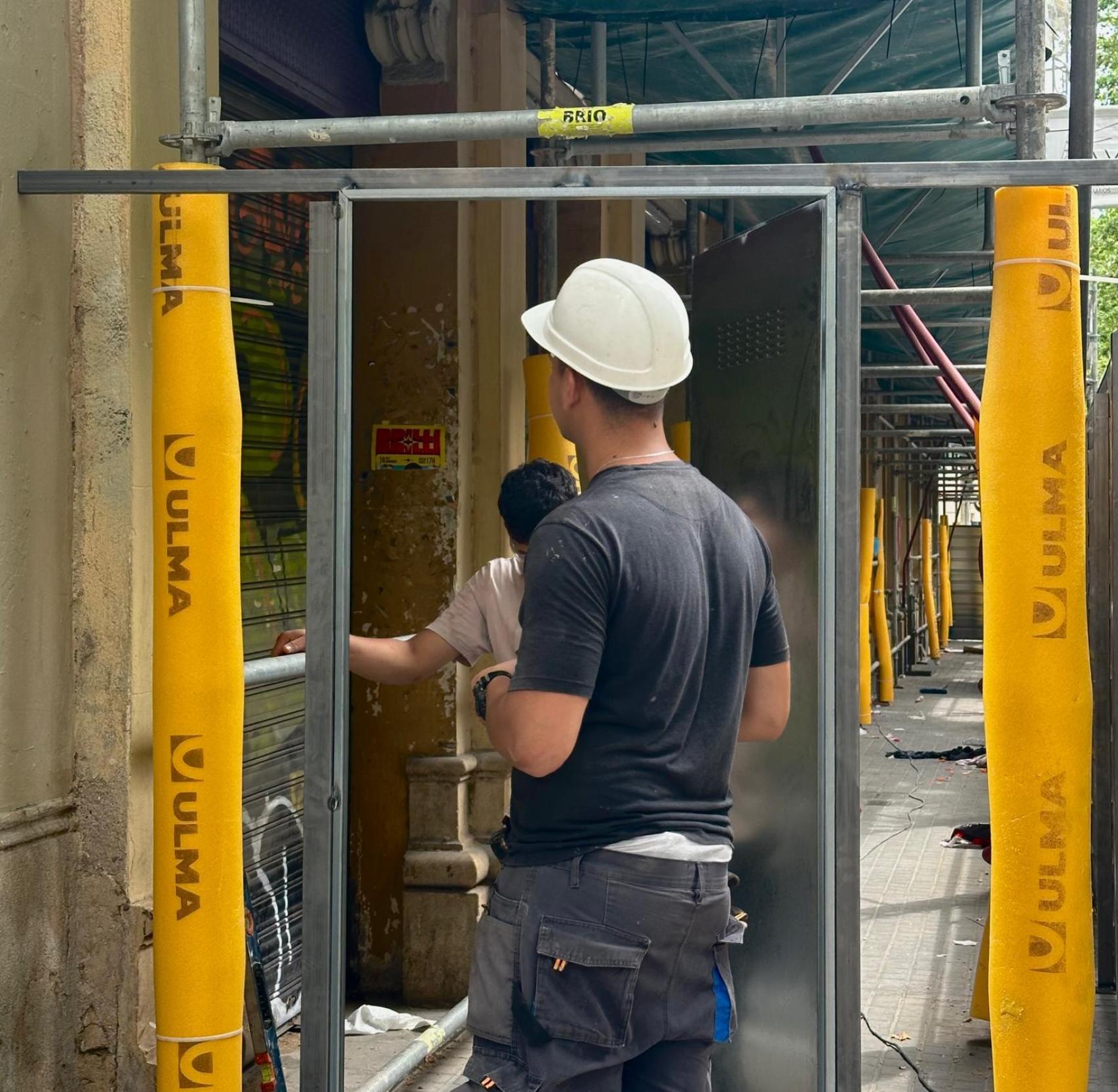 Imatge dels treballadors muntant la porta metàl·lica
