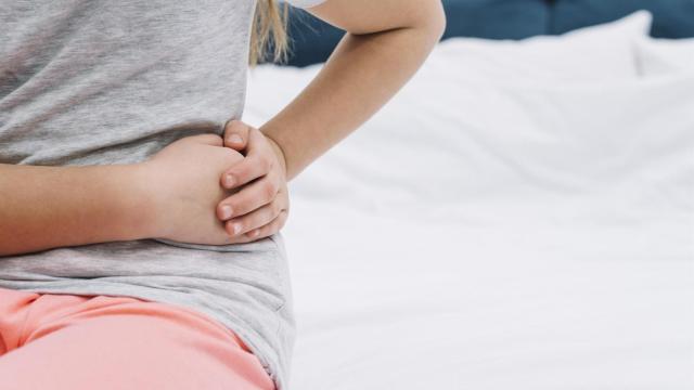 Una joven se queja de dolor en los riñones