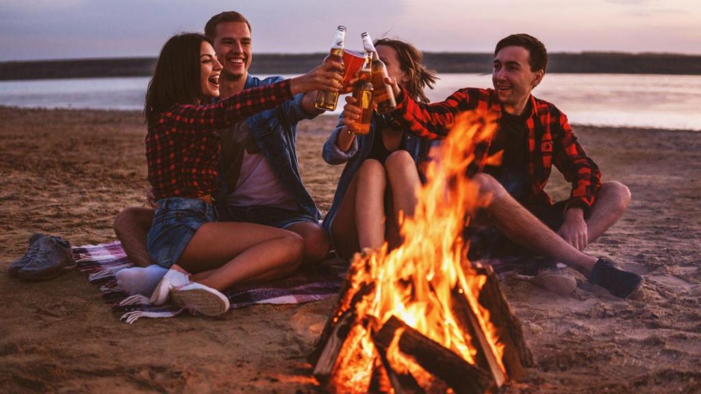 Personas en la playa alrededor de una hoguera