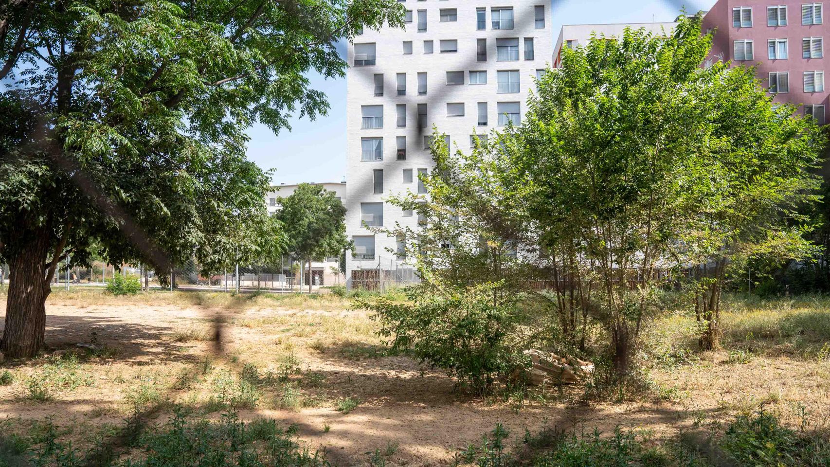 Un solar vacío frente a unos bloques de pisos públicos en las 'Casernes' de Sant Andreu