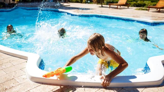 Niños jugando y bañándose en una piscina