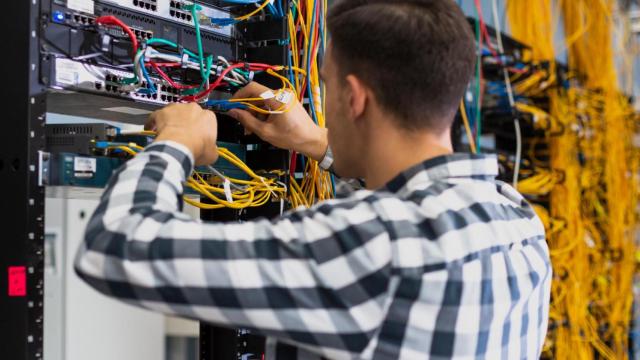 Joven trabajando en un conmutador de Ethernet