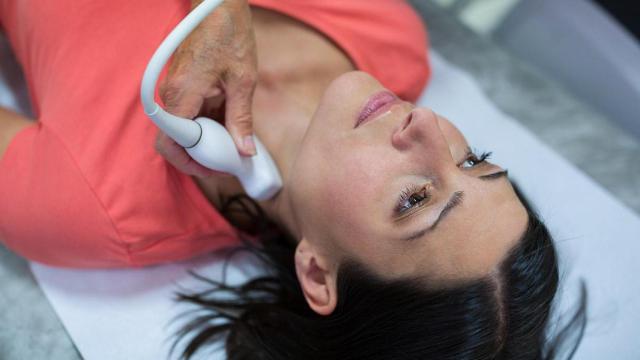 Un especialista observa a una mujer con posible hipertiroidismo