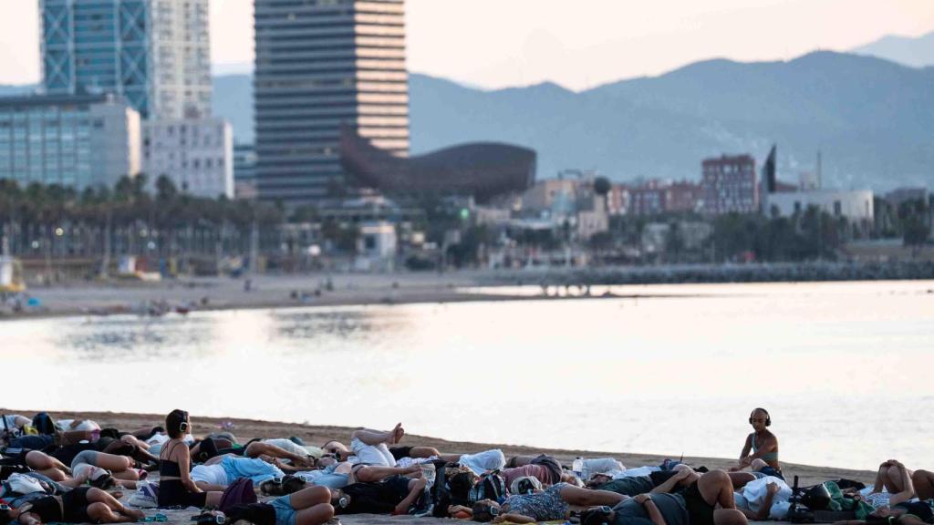 Varios asistentes a una sesión de Showup meditan en la playa de Sant Sebastià
