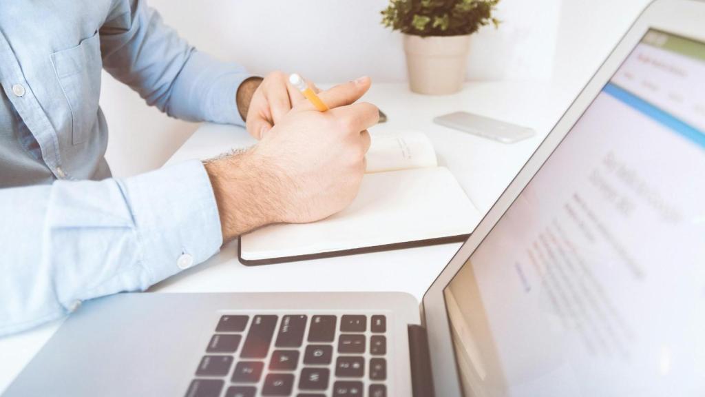 Toma de notas junto a un portátil