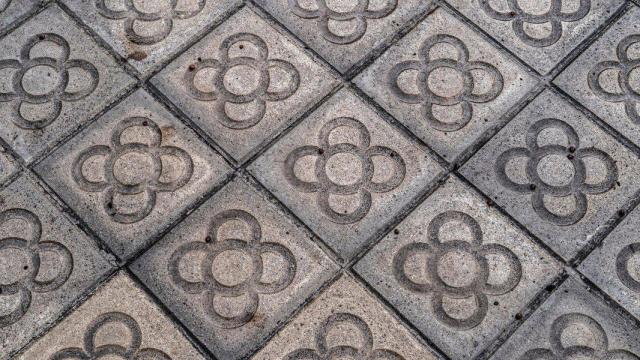 De baldosa funcional a icono urbano: así nació la flor que decora las aceras de Barcelona