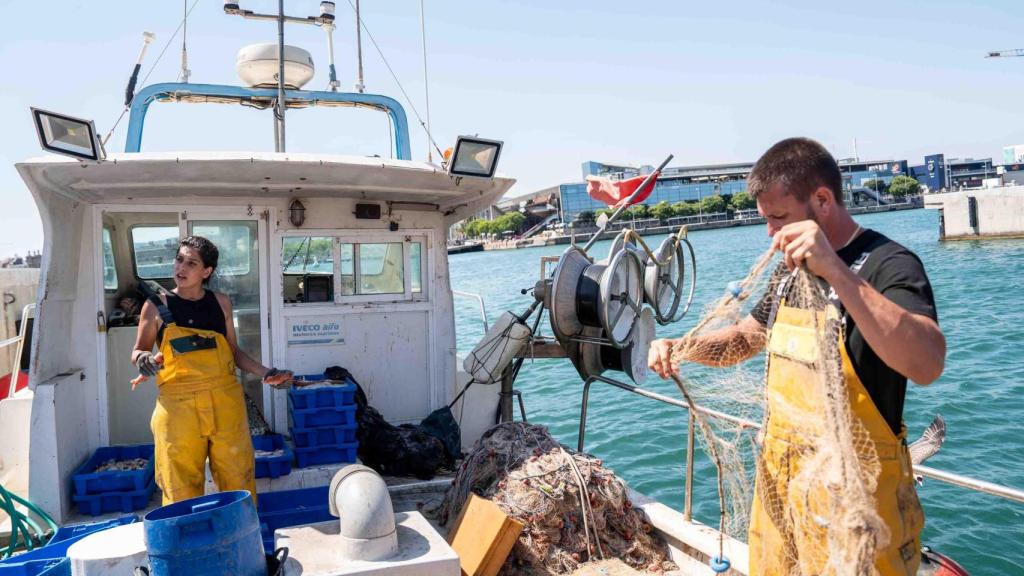 Alba i Cristián preparant recollint les xarxes i preparant el peix
