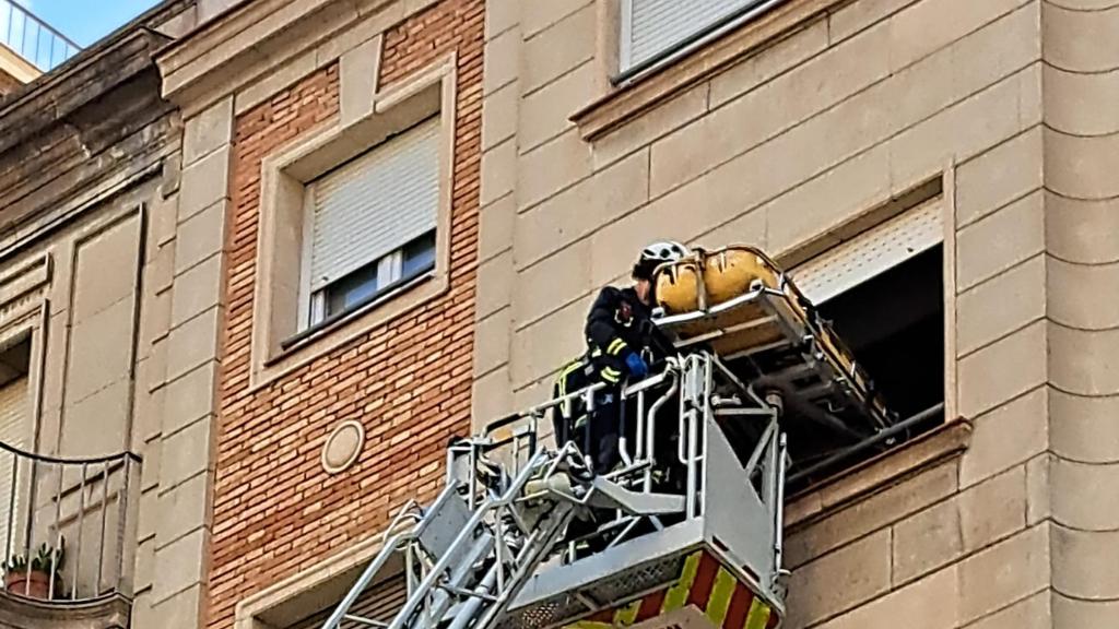 Los bomberos extraen a una persona por la ventana de su domicilio en Gràcia