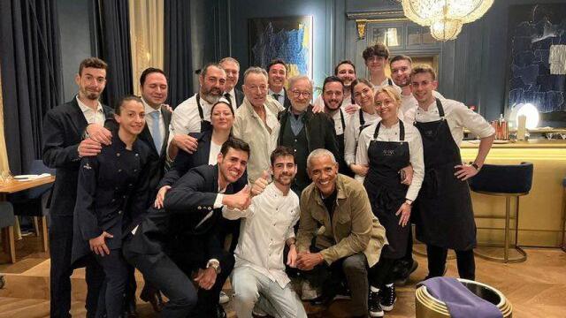 El expresidente de EE. UU. Barack Obama, el director de cine Steven Spielberg y el cantante Bruce Springsteen posan para una foto con el personal del restaurante Amar en Barcelona, España, el 27 de abril de 2023.