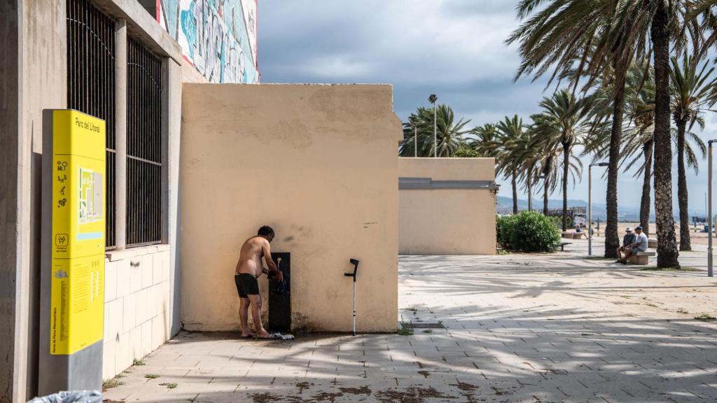 Un home rentant la seva roba a la platja del Litoral de Sant Adrià