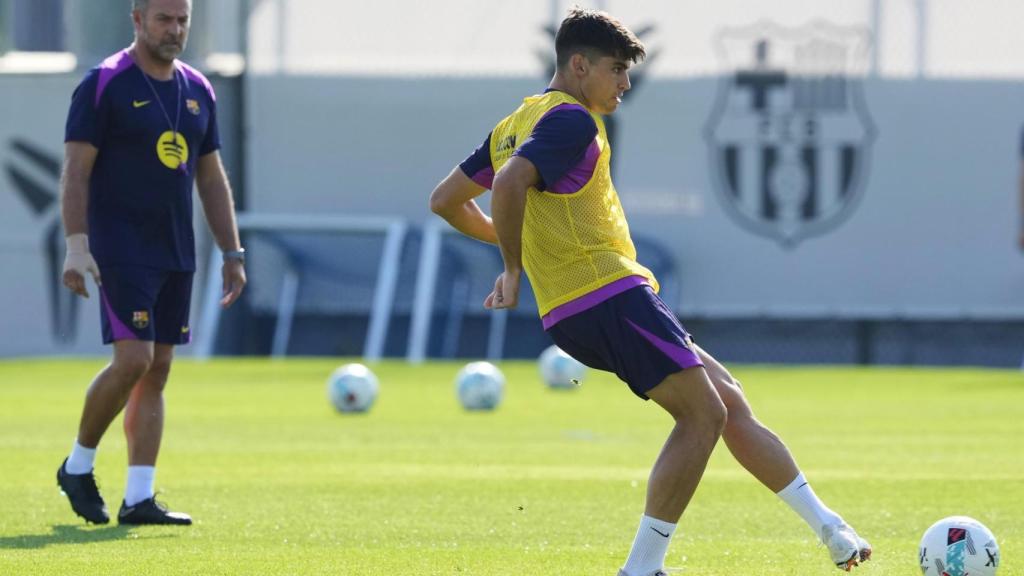 Hansi Flick observa de cerca a Gerard Martín en un entrenamiento con el Barça