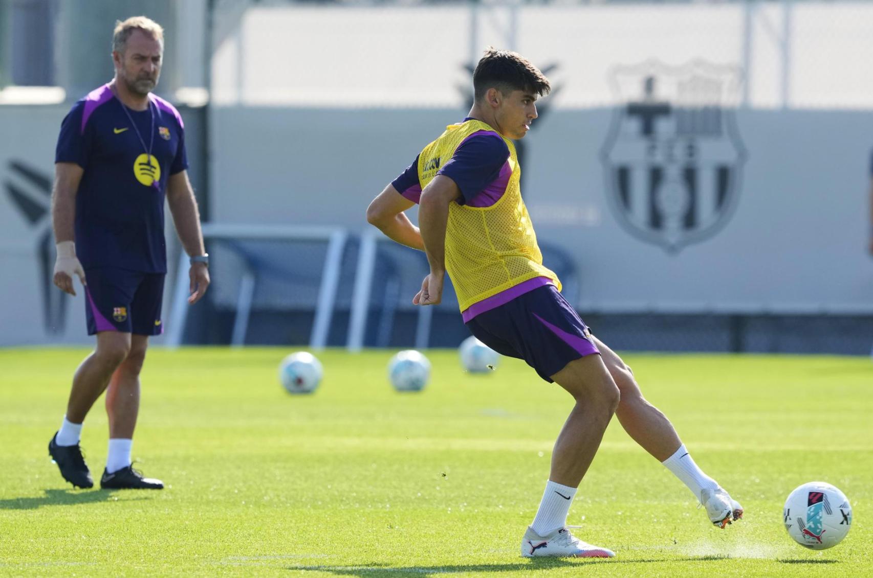 Hansi Flick observa de cerca a Gerard Martín en un entrenamiento con el Barça