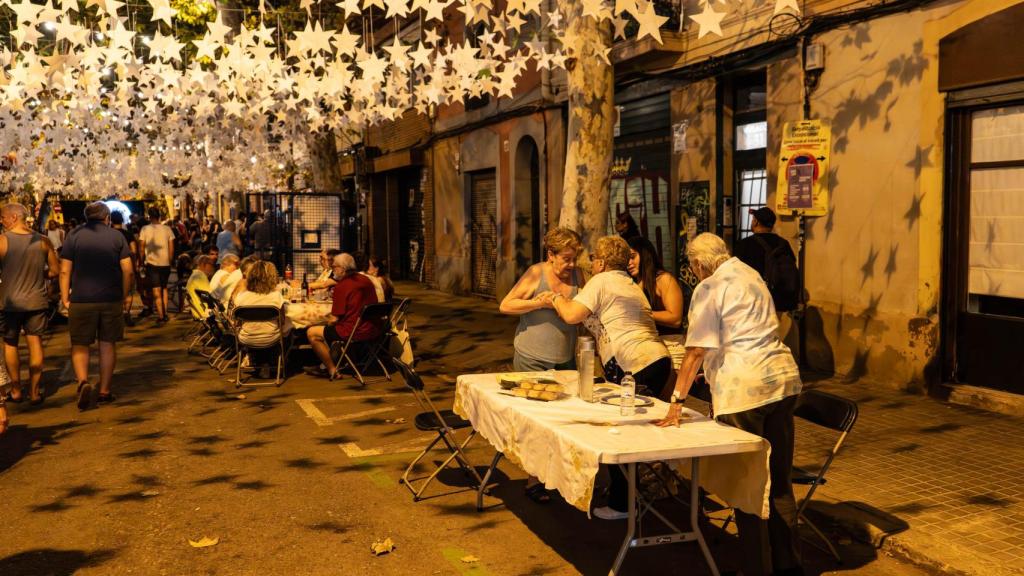 Vecinos del barrio de Sants cenando durante las Fiestas Mayores del barrio