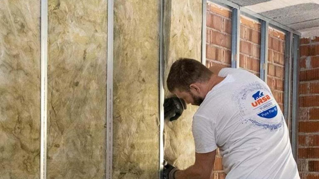 Un operario de URSA trabaja en el aislamiento de un edificio