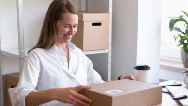 Mujer prepara el envío de un paquete postal