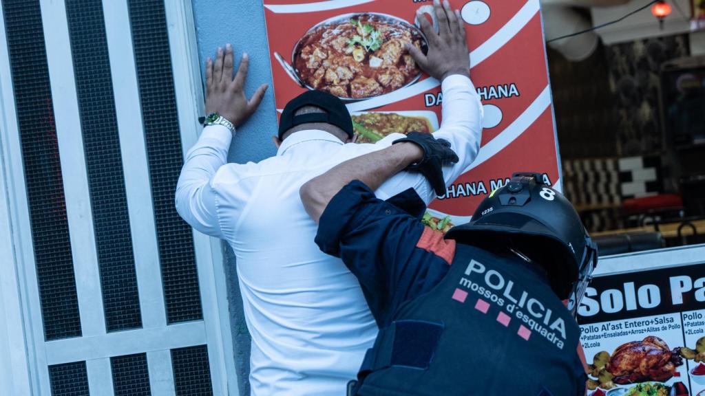 Un agente de los mossos cacheando a un identificado durante el 'Pla Kanpai' en Badalona