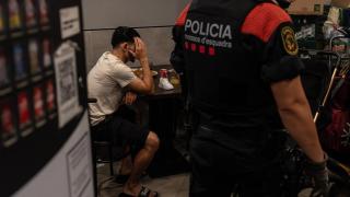 Un agente de los mossos con un identificado durante el 'Pla Kanpai' en Badalona