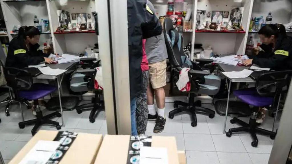 Interior del establecimiento compro oro, donde una agente de la Policía Administrativa hace comprobaciones en el libro de registros