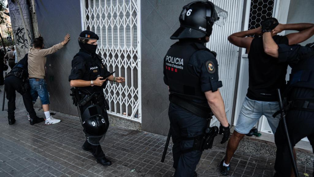 Agentes de la Brimo de los Mossos d'Esquadra cacheando a dos personas que se identificaron en un dispositivo contra la multirreincidencia