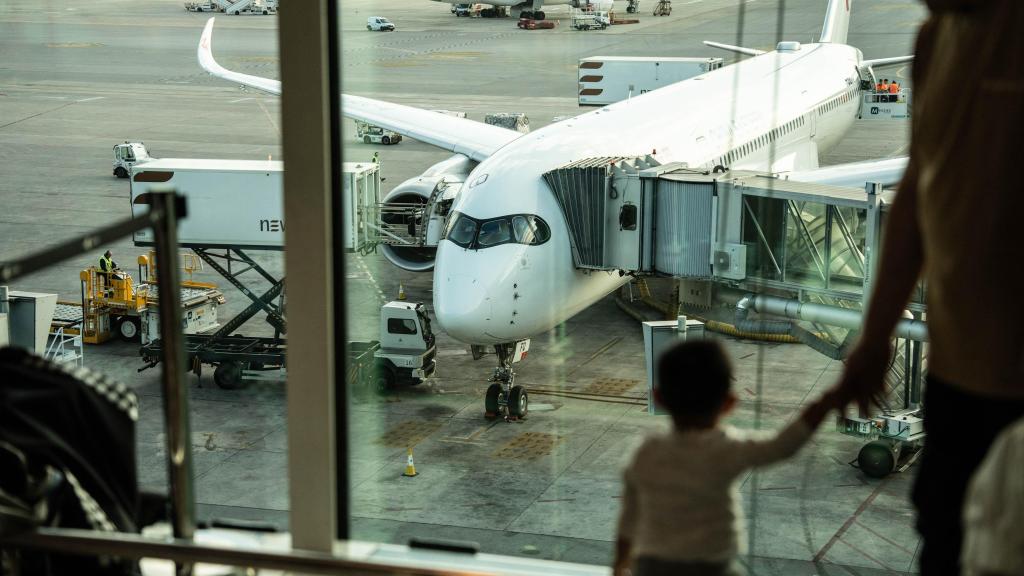 Un niño observa un avión de China Eastern Airlines en el Aeropuerto de Barcelona