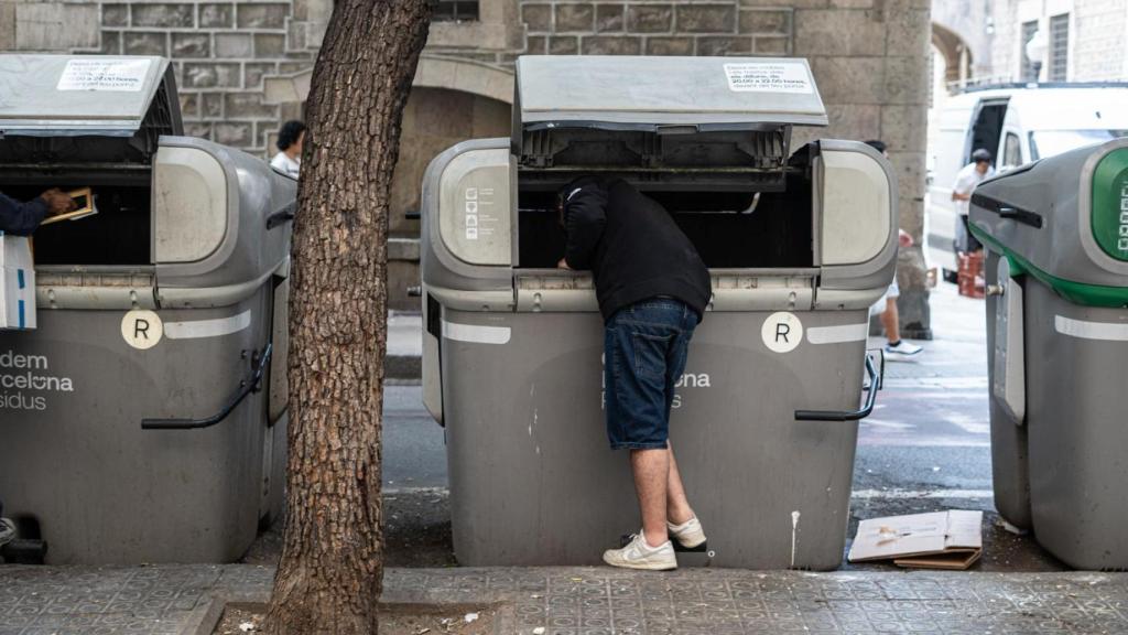 Un home remenant a la brossa al Raval