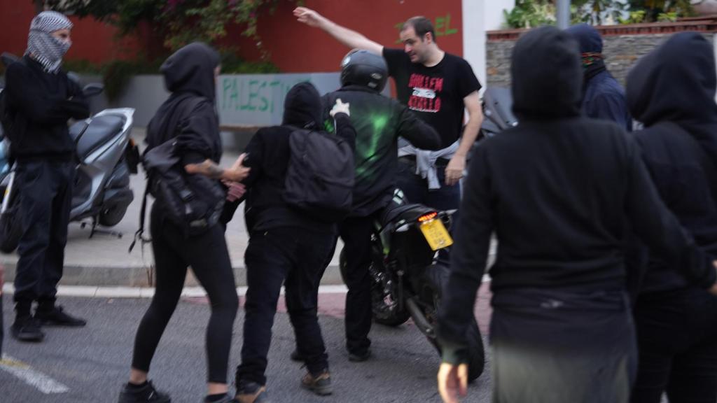 Conductor de una moto con espalda grafiteada por una manifestante