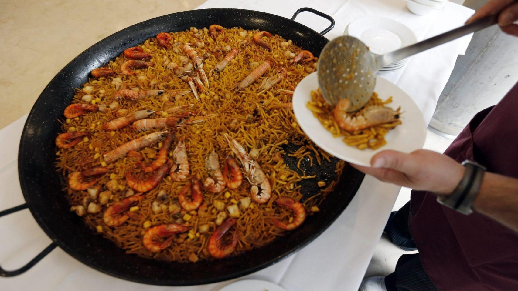 Un hombre sirve una fideuá en una imagen de archivo