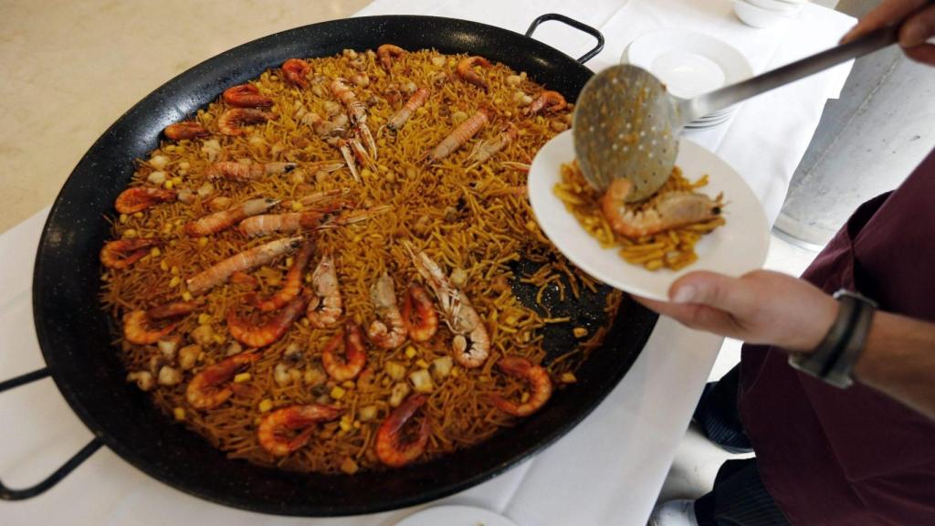 Un hombre sirve una fideuá en una imagen de archivo