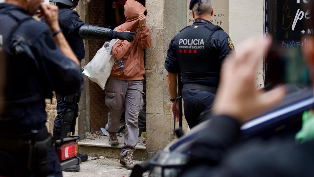 Una de las okupas de Ca l'Espina abandonando el edificio durante el desalojo ejecutado por mossos