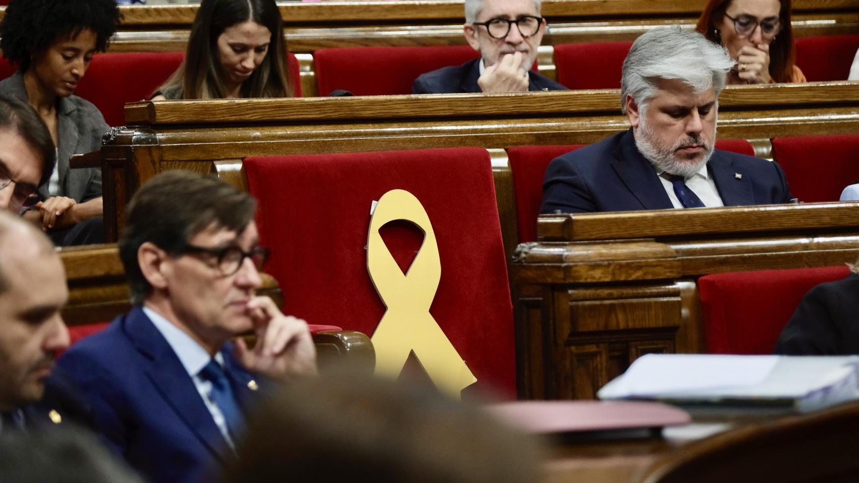 Salvador Illa, presidente de la Generalitat, Albert Batet, presidente del grupo parlamentario de Junts, y el escaño vacío de Carles Puigdemont durante el Debate de Política General