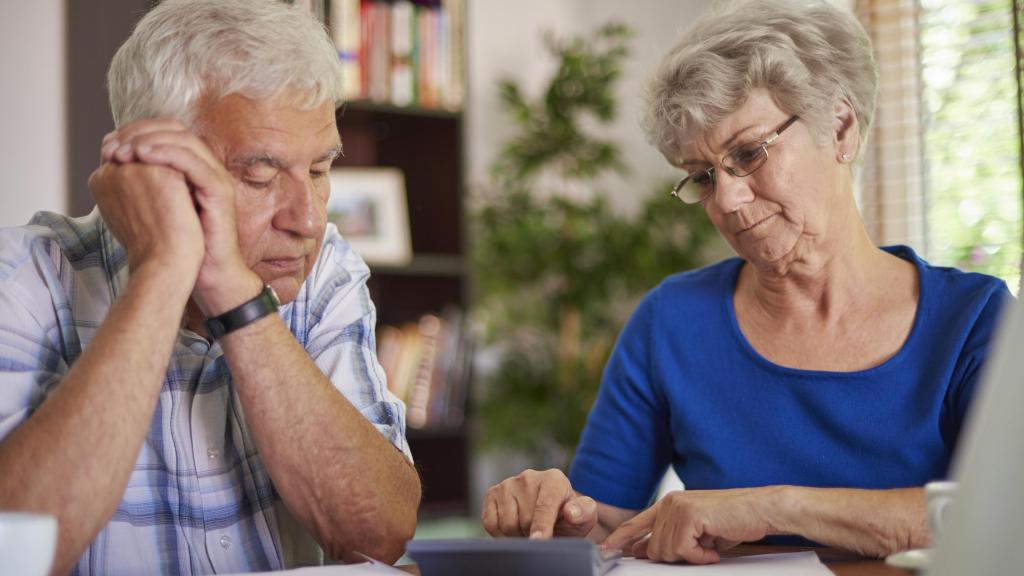 Dos ancianos haciendo cálculos financieros