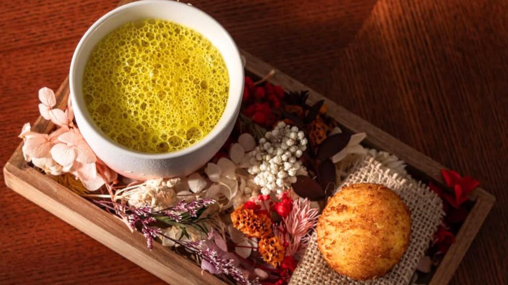 Croqueta de pollo satay con caldo clarificado de pollo y limón kefir y con aire de cúrcuma