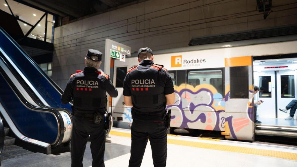Agentes de los mossos en una estación de Renfe con un tren vandalizado