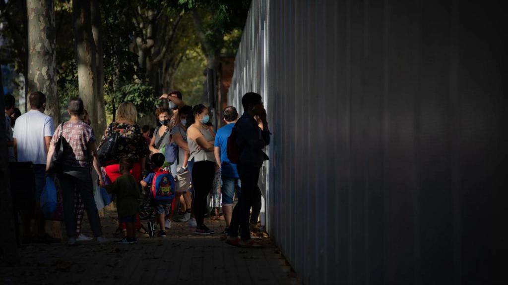 Padres y alumnos esperando en la puerta de una escuela de Barcelona