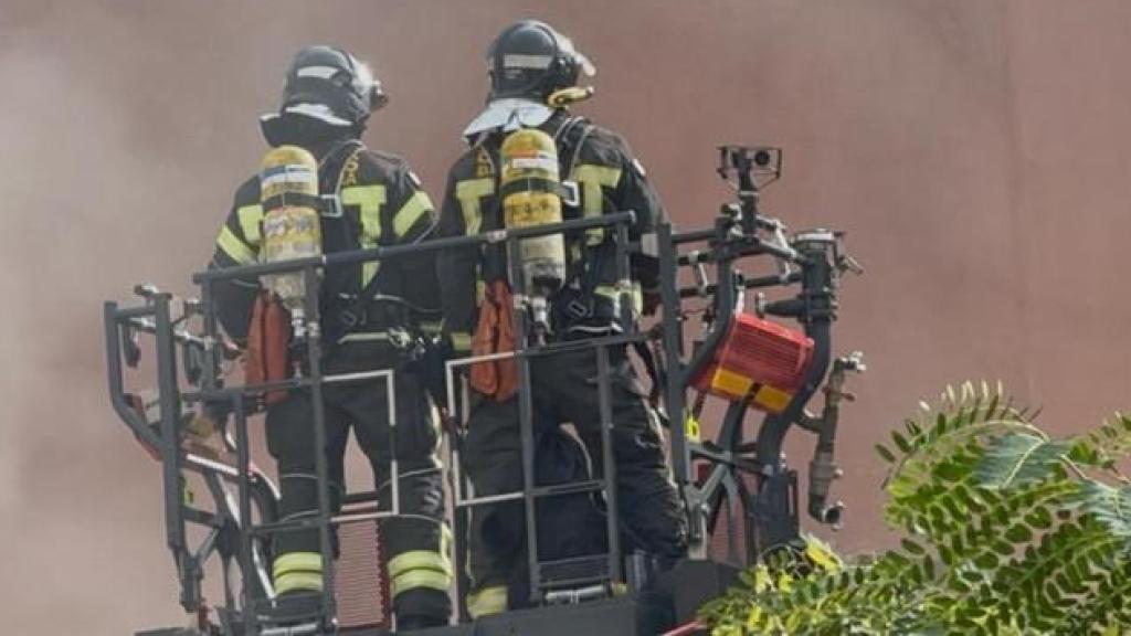 Bomberos accediendo al piso en llamas en el Raval