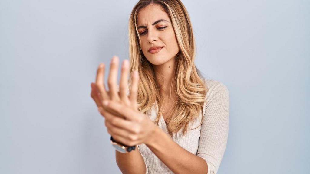 Una mujer se queja de un dolor en la mano