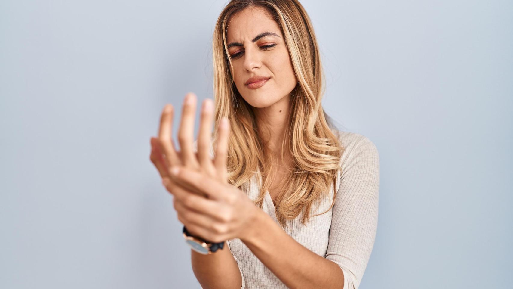 Una mujer se queja de un dolor en la mano